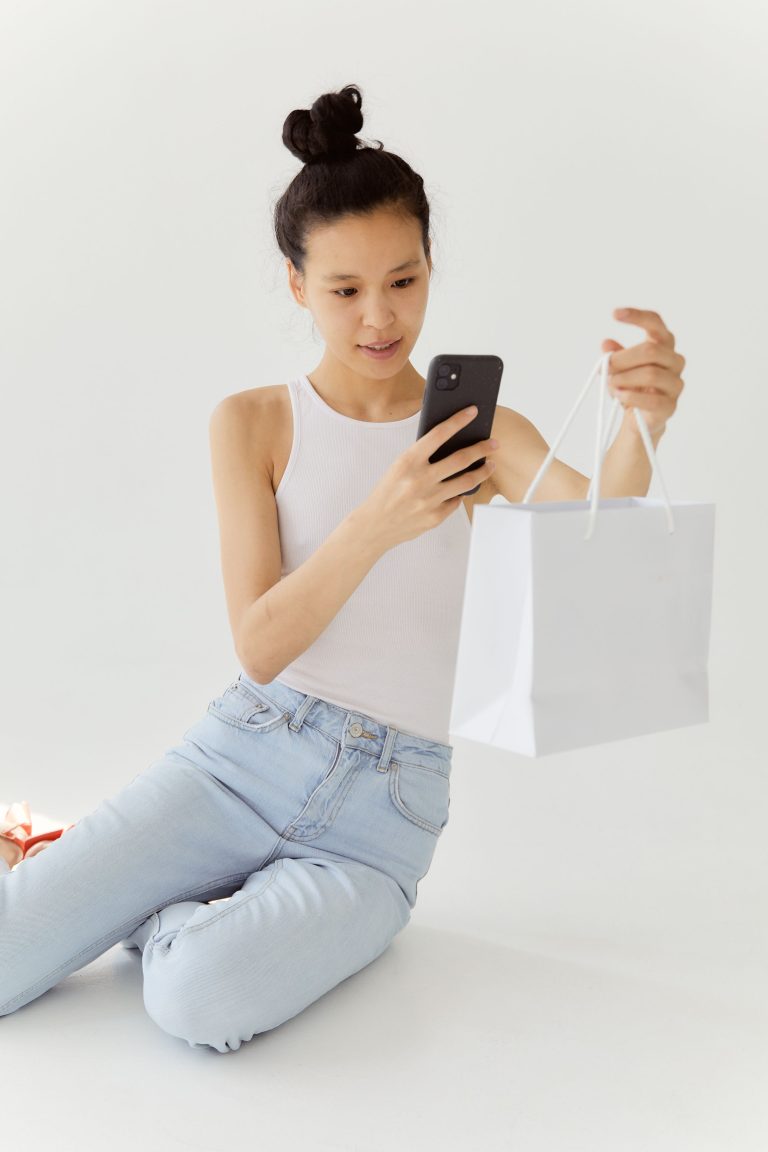 Woman checking her phone after receiving an online order confirmation with delivery details
